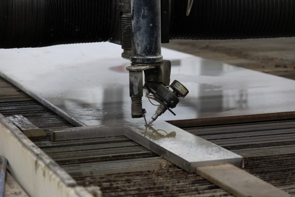 5-axis waterjet bevel cutting examples, including tapered and angled edges, precision holes, and clean cuts on metal parts.